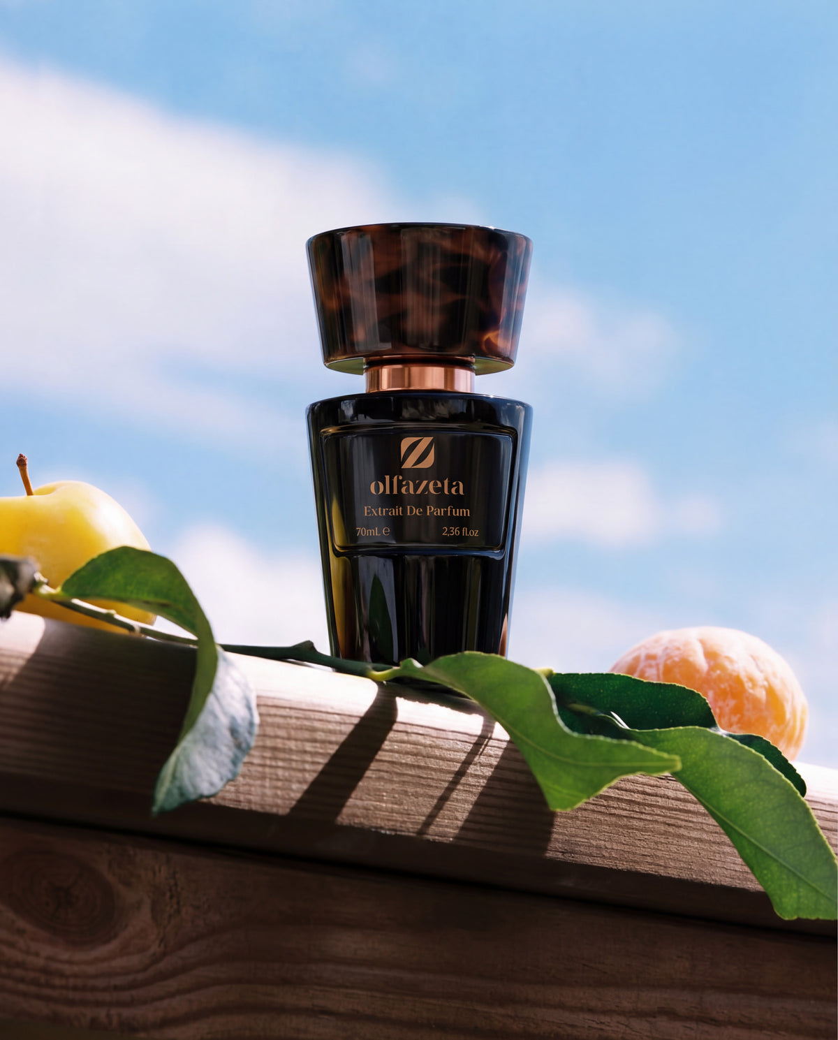 Black Olfazeta by Chogan Millésime N°150 bottle on a wooden beam, apple and mandarin under a blue sky