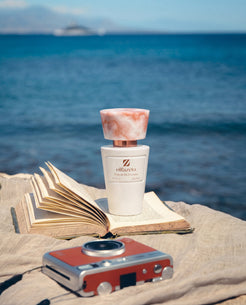 White Olfazeta by Chogan Millésime N°29 bottle, pink marbled cap, on an open book facing the sea